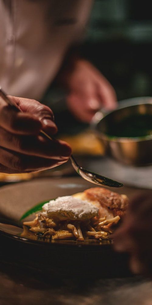 Chef maakt een gerecht zorgvuldig op in de keuken